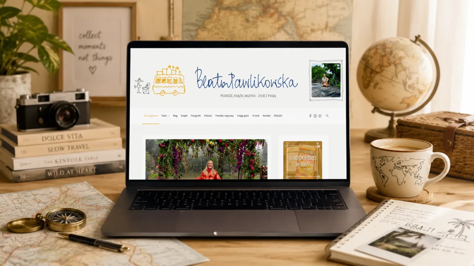 Blog Beaty Pawlikowskiej pokazany na ekranie laptopa w podróżniczym otoczeniu