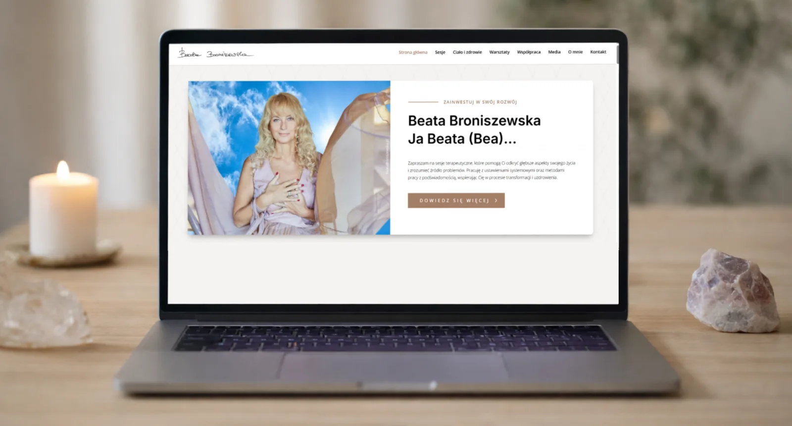 Strona Beaty Broniszewskiej – terapeutki holistycznej – na ekranie laptopa na tle świecy i kryształów