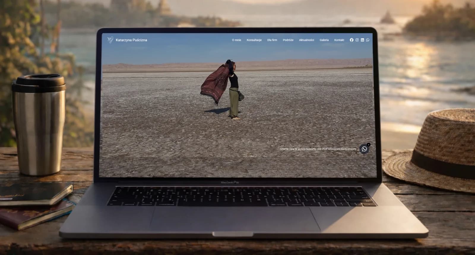 Hero strony Katarzyny Puścizny – laptop z widokiem pustynnego krajobrazu i podróżniczką na ekranie