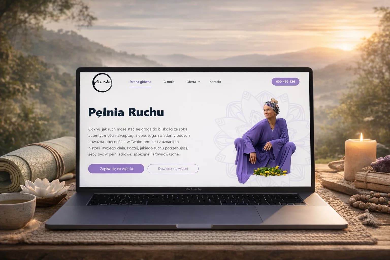 Strona Pełnia Ruchu wyświetlona na laptopie w otoczeniu akcesoriów do jogi, świec i natury